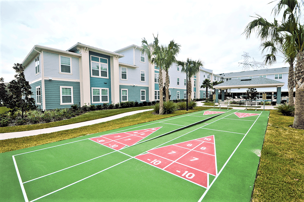 a basketball court in front of a row of houses